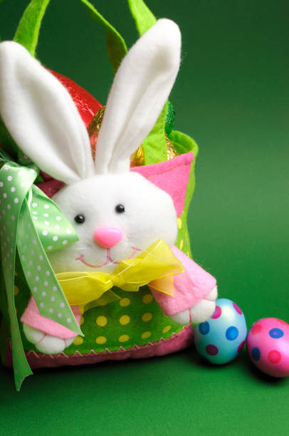 Happy Easter, home made Easter egg hunt colorful polka dot carry basket bag and chocolate Easter eggs on green background.