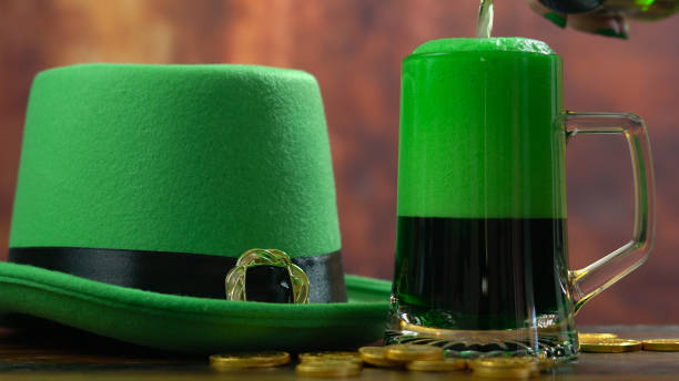 istock St Patrick's Day pouring green beer with green leprechaun hat 921432164