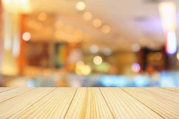 istock wooden table top with abstract blurred cafe restaurant bokeh lights defocused background 921437144
