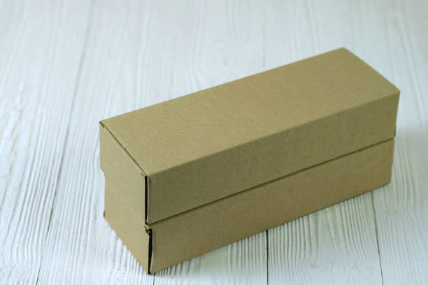 istock Empty Package brown cardboard box or tray on bright wooden table with copy space. 921437484