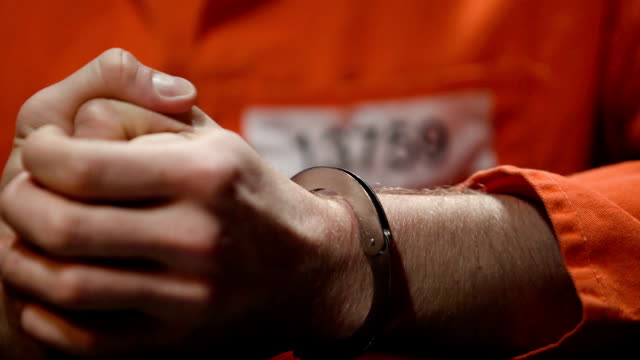 Anxious prisoner kneading fingers, regrets about committing crime, hands closeup