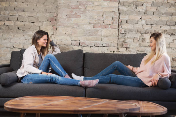 istock Two beautiful young women having a conversation on the sofa 921449046