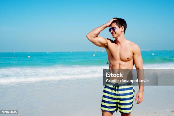 Handsome Shirtless Muscular Fitness Man At The Beach Looking Aside And Smiling Stock Photo - Download Image Now