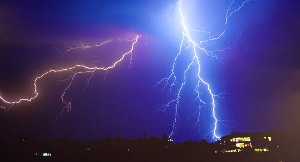 Lightnings, thunderstorm and rain in summer Lightning over the town during summer storm at night. lightning storm natural disaster cloud stock pictures, royalty-free photos & images