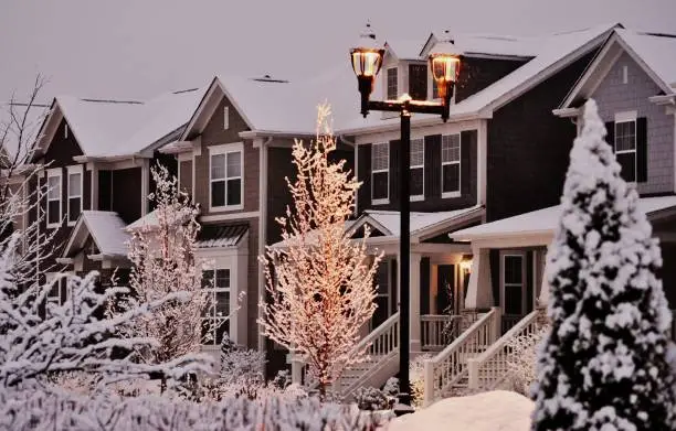 Photo of Snow- covered townhouses at dusk.