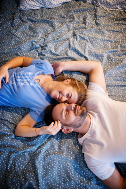 istock Romantic lovely couple lying on the bed with eyes closed with bodies in opposite ways while cuddling each other. 921461864