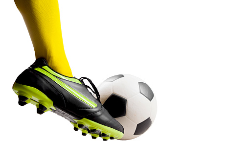 Isolated Close up shot of footballer feet kicking soccer ball over white background