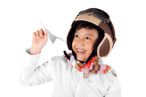 istock Smiling Asian boy wearing helmet holding a plane paper 921475324
