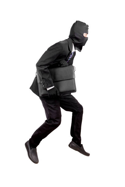 istock Thief dressed in black and wearing a balaclava stealing a bag 921475336