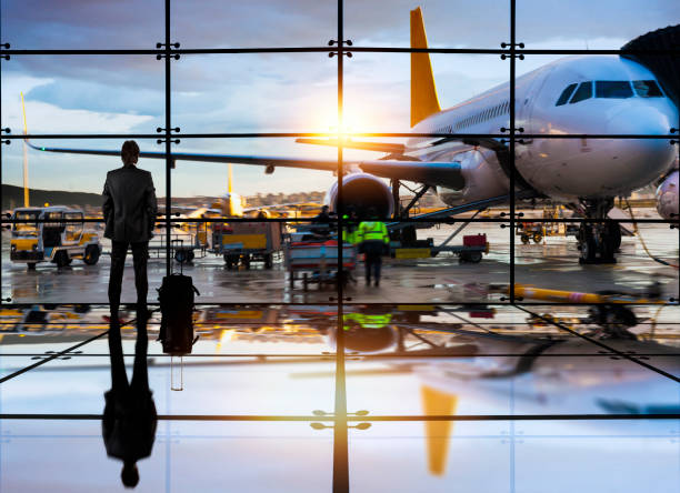 Business man waiting to board a flight in airport Passenger airplane getting ready for flight and business man waiting to board a flight in airport airport runway photos stock pictures, royalty-free photos & images