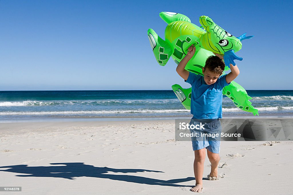 Rapaz carregar Insuflável Dragão ao longo da praia - Royalty-free De Corpo Inteiro Foto de stock