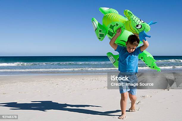 Rapaz Carregar Insuflável Dragão Ao Longo Da Praia - Fotografias de stock e mais imagens de De Corpo Inteiro - De Corpo Inteiro, Rapazes, Criança