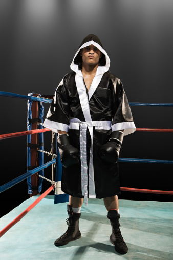 Young male athlete wearing blue boxing gloves