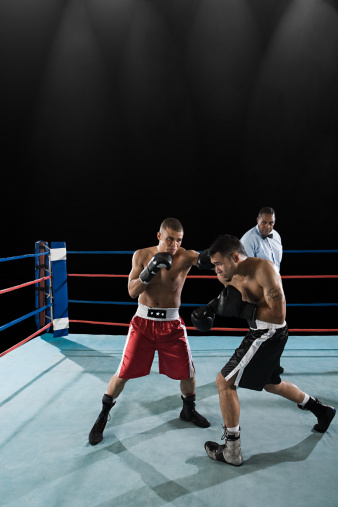 A modern oversized boxing ring with opposing blue and red corners on an isolated white studio background - 3D render