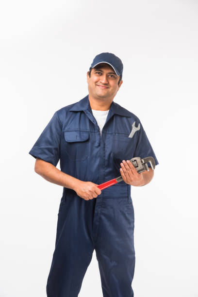 istock Indian happy auto mechanic in blue suit and cap holding spanner tool in action, isolated over white background 921493972