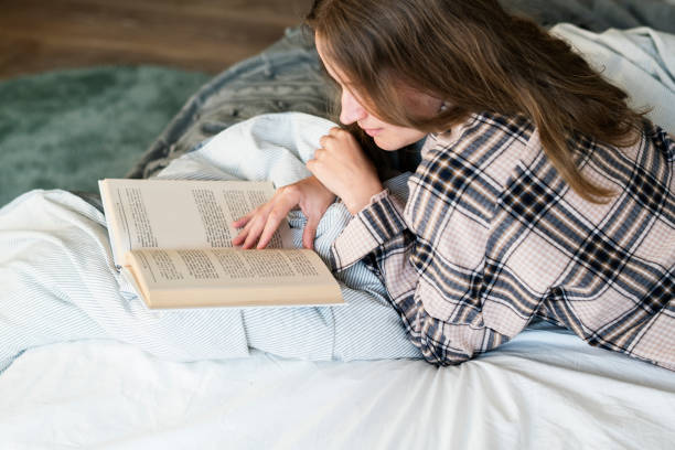 istock Caucasian woman reading book in bed 921501144