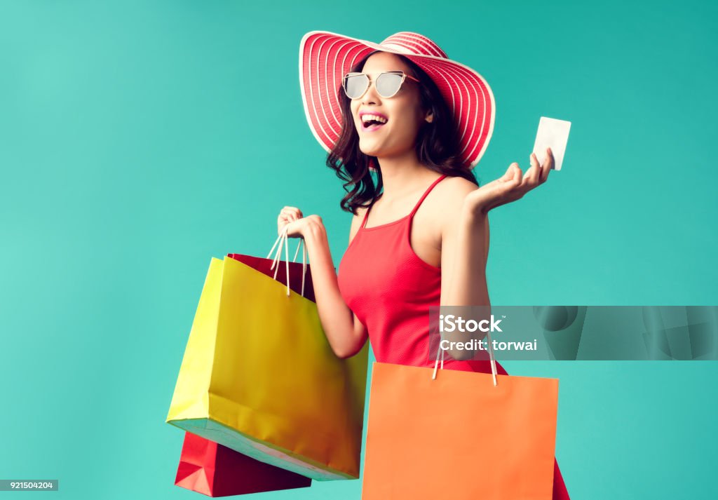 Las mujeres son ir de compras en el verano se está utilizando una tarjeta de crédito y disfruta ir de compras. - Foto de stock de Ir de compras libre de derechos