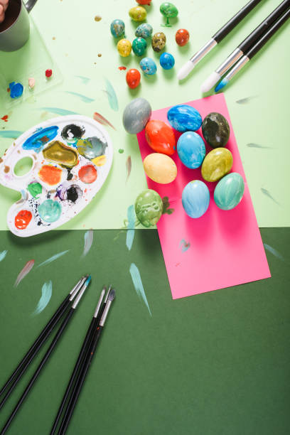 istock Painted chicken and quail easter eggs, brushes and paints on a colorful background 921509328