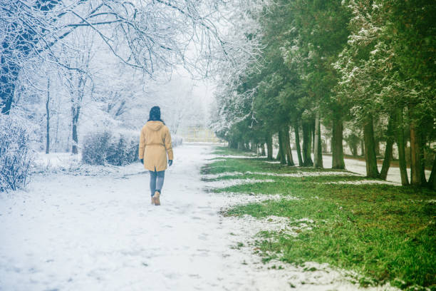 istock woman walk by park where winter meet spring 921516352