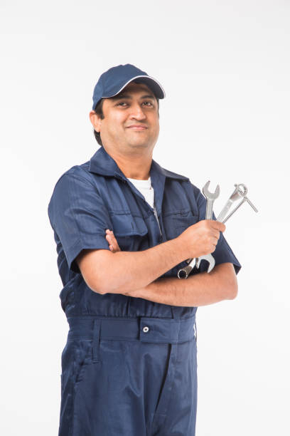 istock Indian happy auto mechanic in blue suit and cap holding spanner tool in action, isolated over white background 921526868