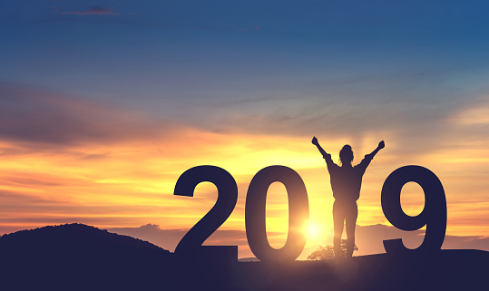 Silhouette young woman enjoying on the hill and 2019 years while celebrating new year