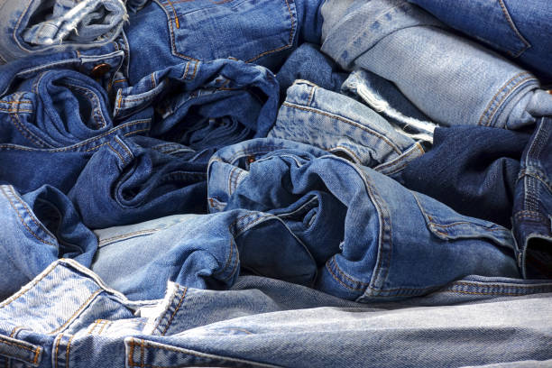 istock Heap of different blue jeans as a background 921531676