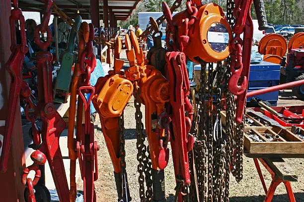 A collection of hoists and chains for sale at an outdoor flea market.