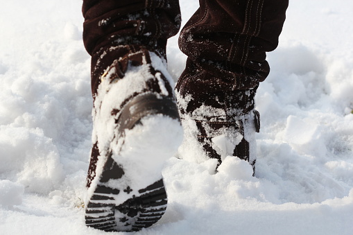 Brown women's shoes covered by snow in the winter.