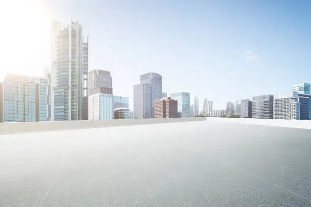 Photo of Empty space top floor car park with modern skyscraper building .