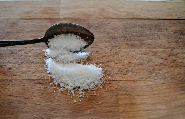 istock Sea salt whit spoon at wooden background 921560380