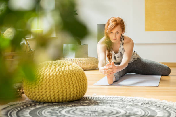 Woman exercising at home Attractive woman exercising on the floor at home with yellow decorations ginger health stock pictures, royalty-free photos & images