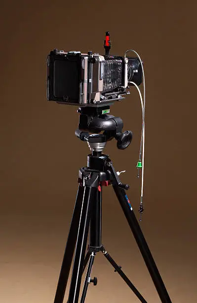 studio shot of aprofessional camera on stand in brown background
