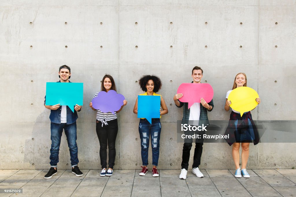 Group of young adults outdoors holding empty placard copy-space thought bubbles Teenager Stock Photo