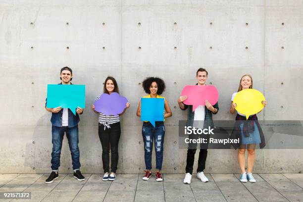 Foto de Grupo De Jovens Adultos No Exterior Segurando Cartaz Vazio Balões De Pensamento De Cópiaespaço e mais fotos de stock de Adolescente