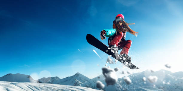 salto femenino snowboarder extremo de freestyle - snowboarding extreme sports action snowboard fotografías e imágenes de stock