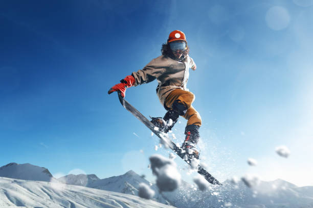 Male extreme freestyle snowboarder jump
