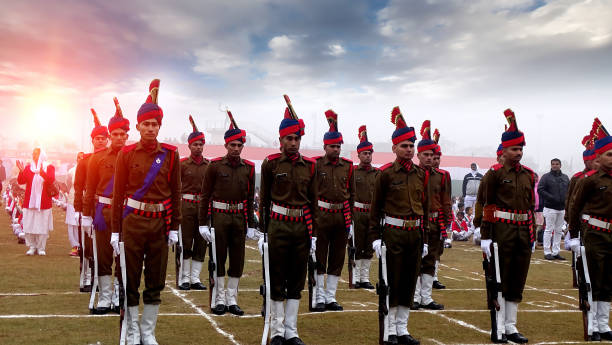 Haryana, India – January 26, 2017: Indian army soldiers standing together in rows  with pride  during republic day celebration at the time of sunrise during winter season in stadium on the grass wearing uniform & looking towards the camera also the celebration event happening in Rohtak which is a smalll city of Haryana state India. all soldier standing alert in the rows also wearing army uniform.