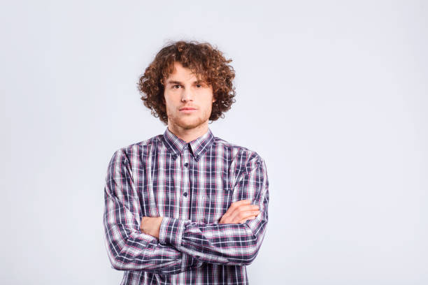 istock A curly-haired guy looks with a serious emotion 921574800
