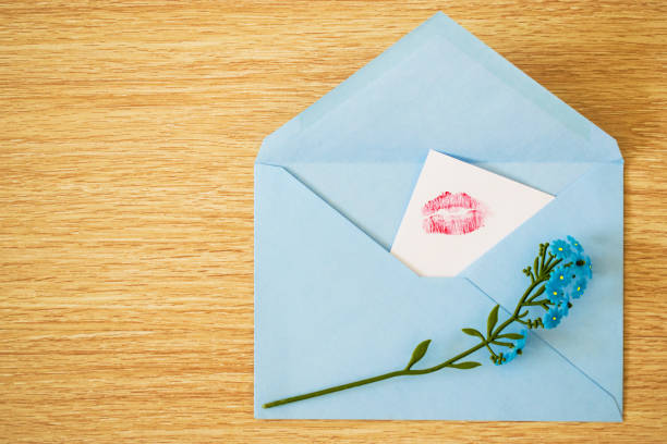 istock Blue envelope with artificial flowers forget-me-nots and a kiss 921577152