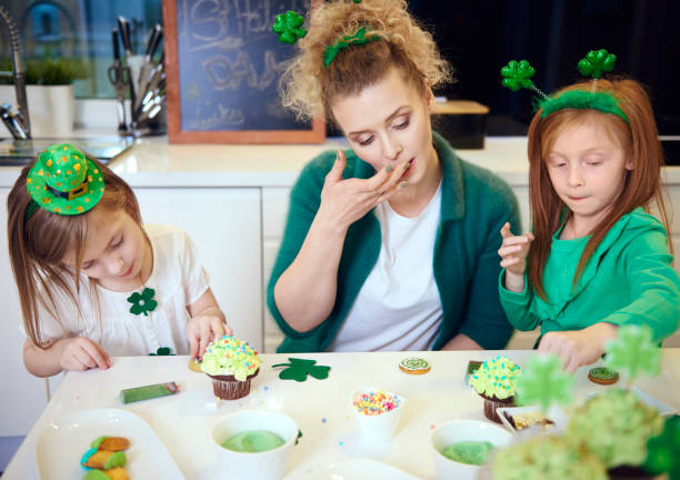 istock Mother with children decorating cupcakes at kitchen 921581130