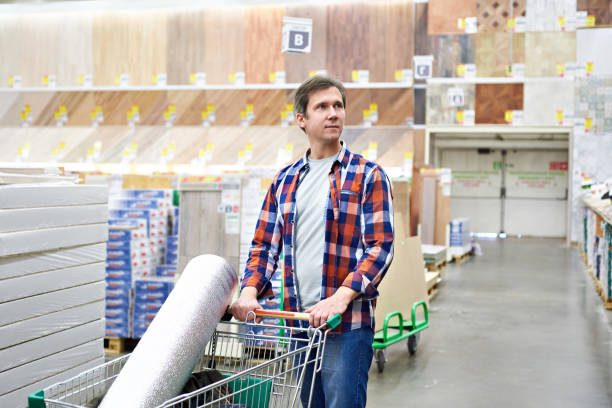 Man chooses and buys goods in store Man chooses and buys wooden board in a construction supermarket construction material stock pictures, royalty-free photos & images