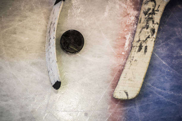 istock Hockey puck and stick on ice! 921584636