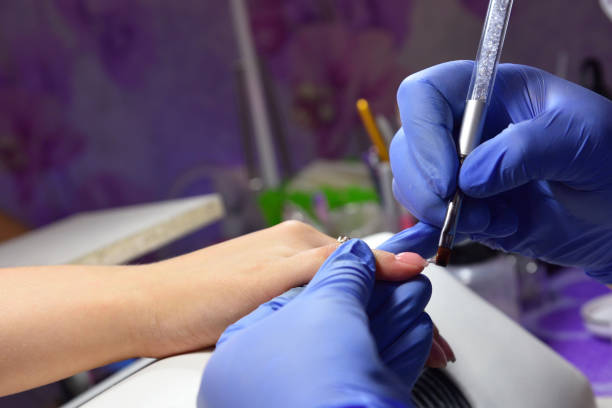 istock Manicurist with a brush applied to the nails a gel 921587972