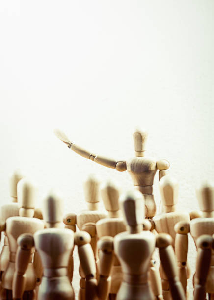 istock Wooden lay figure addresses a crowd, pointing 921588270