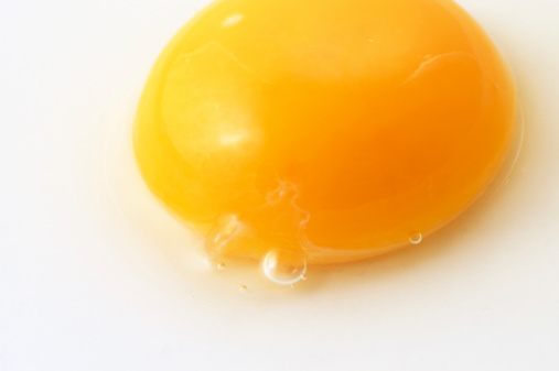 orange yolk and yellow yolk in egg shell on a cooking table.