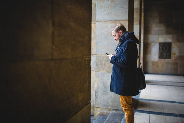istock Young ginger businessman using mobile phone outdoors 921591006