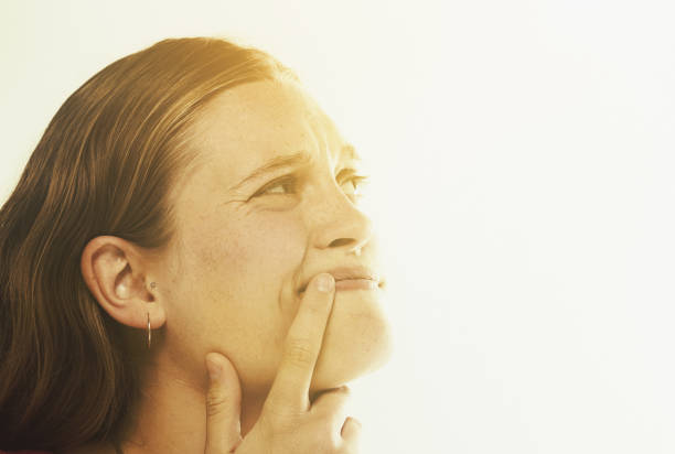 istock Finger to lip, young girl is thinking 921591420