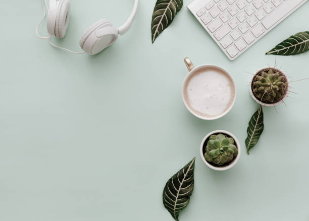 istock Neutral Minimalist Flat Lay Scene With coffee, keyboard, headphones and cactus 921591610