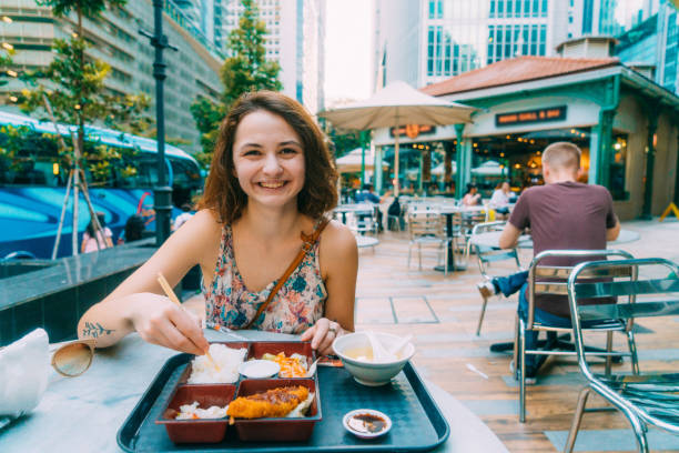 Woman eating Japanese food in Lau Pa sat market in Singapore stock photo