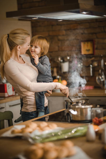 istock Loving mother and son talking while cooking lunch in the kitchen. 921594368